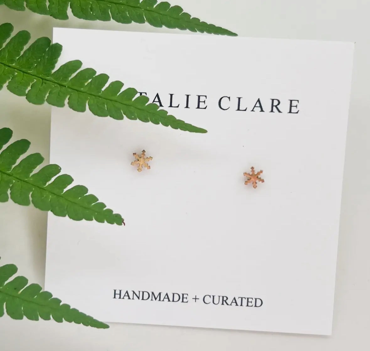 Pair of snow flake studs with green leaves around