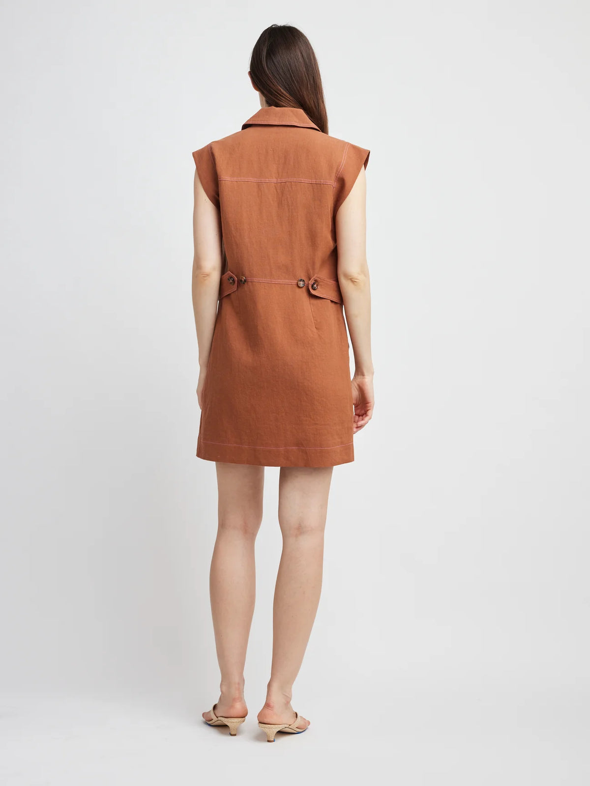 Woman wearing a brown sleeveless dress on a white background