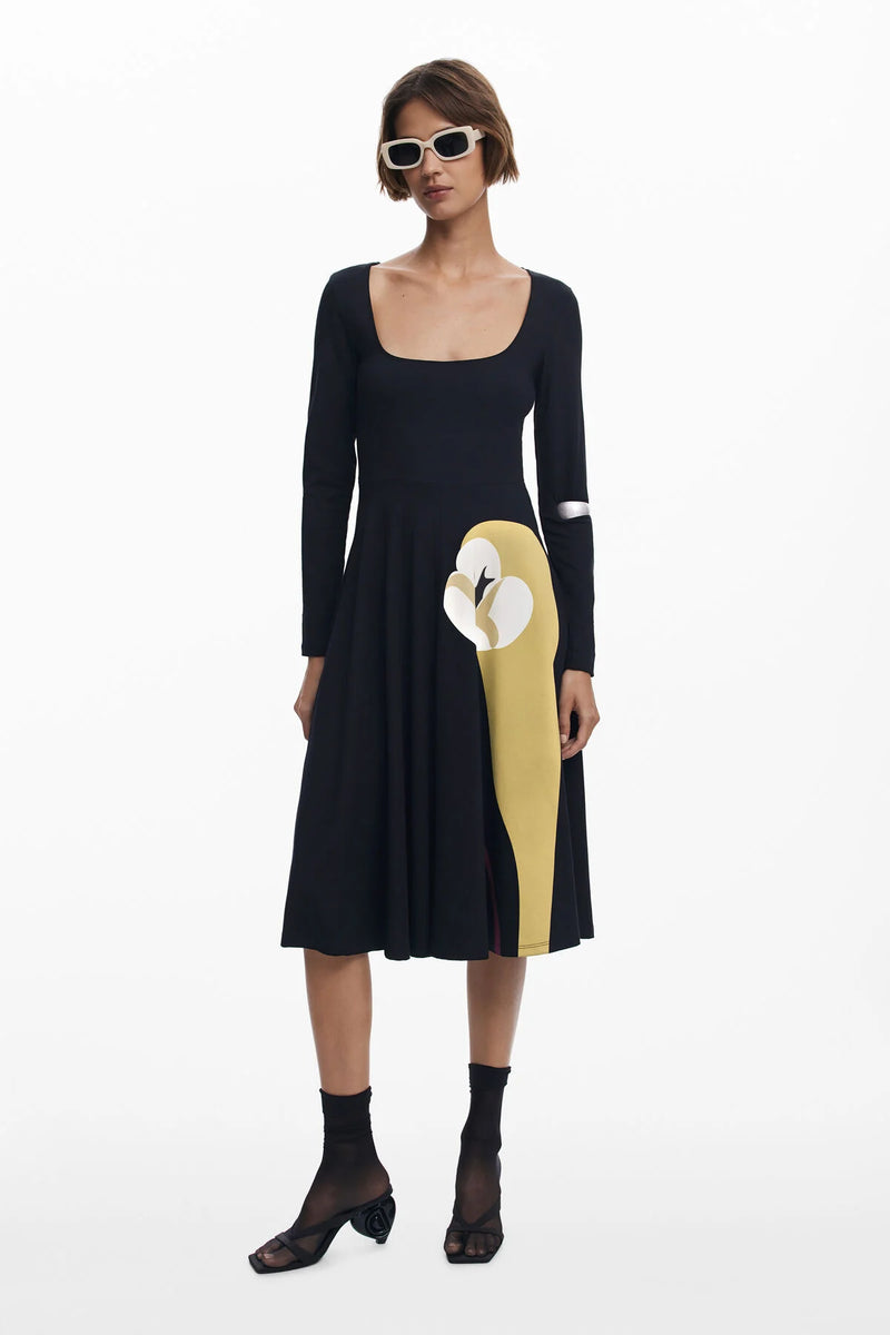 Woman wearing a black dress with a yellow and white design on a white background