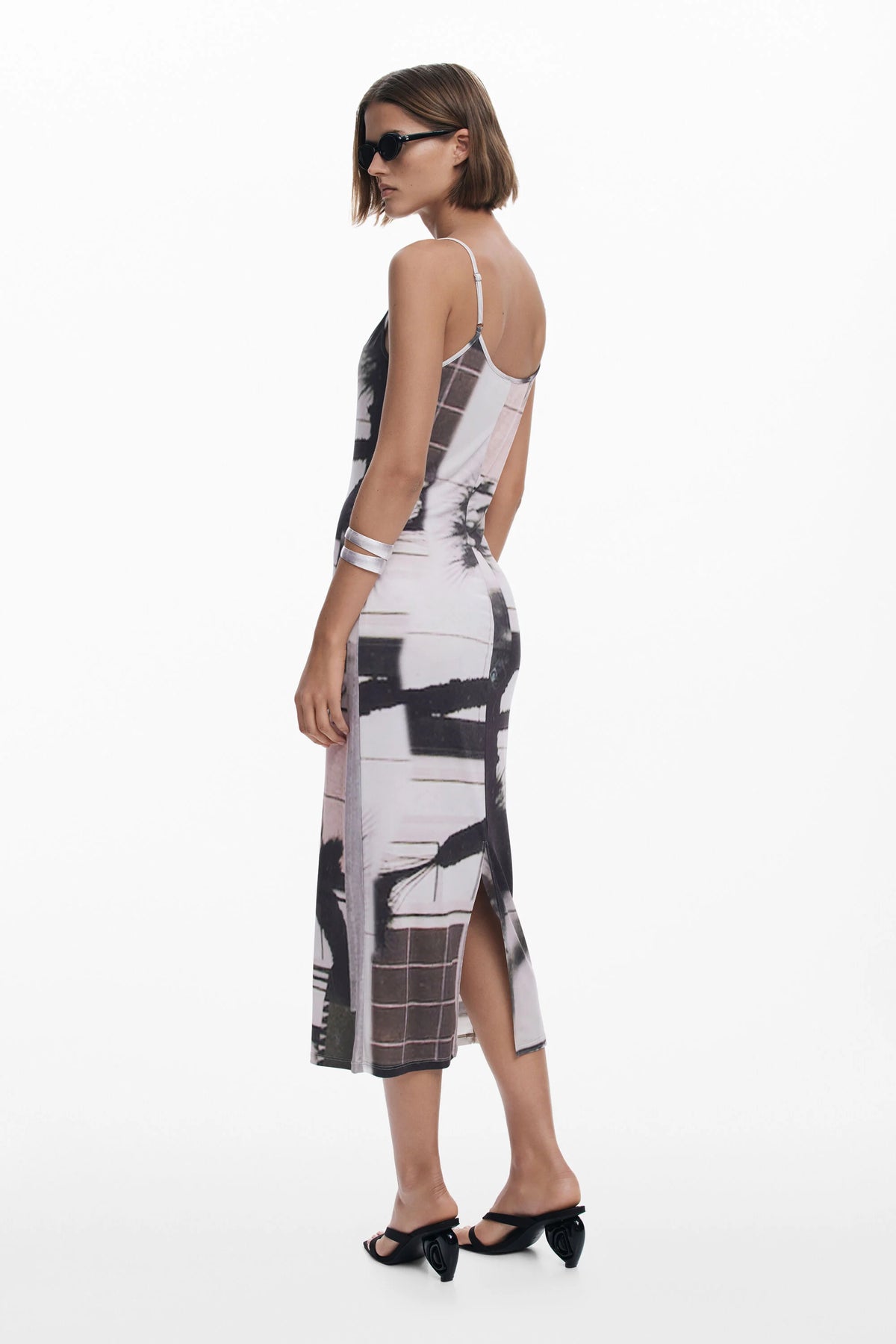Woman wearing a black and white patterned dress on a white background
