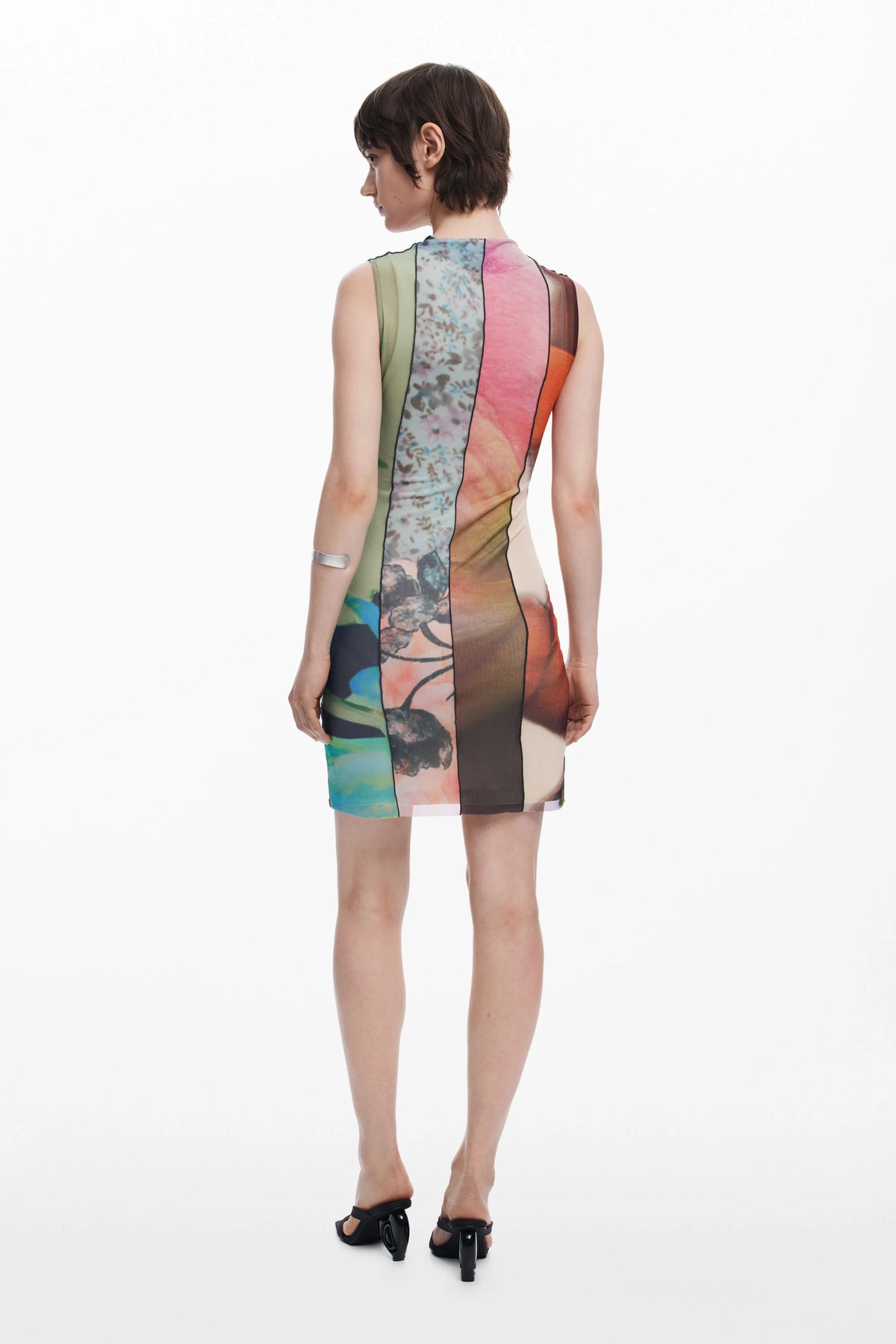 Woman wearing a colorful dress with abstract patterns on a white background