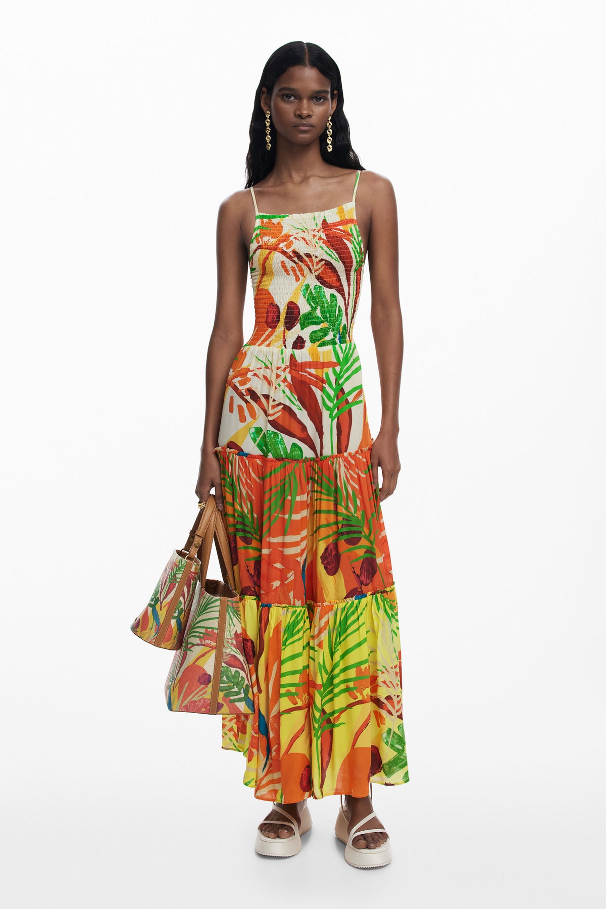 Woman wearing a colorful tropical print dress on a white background