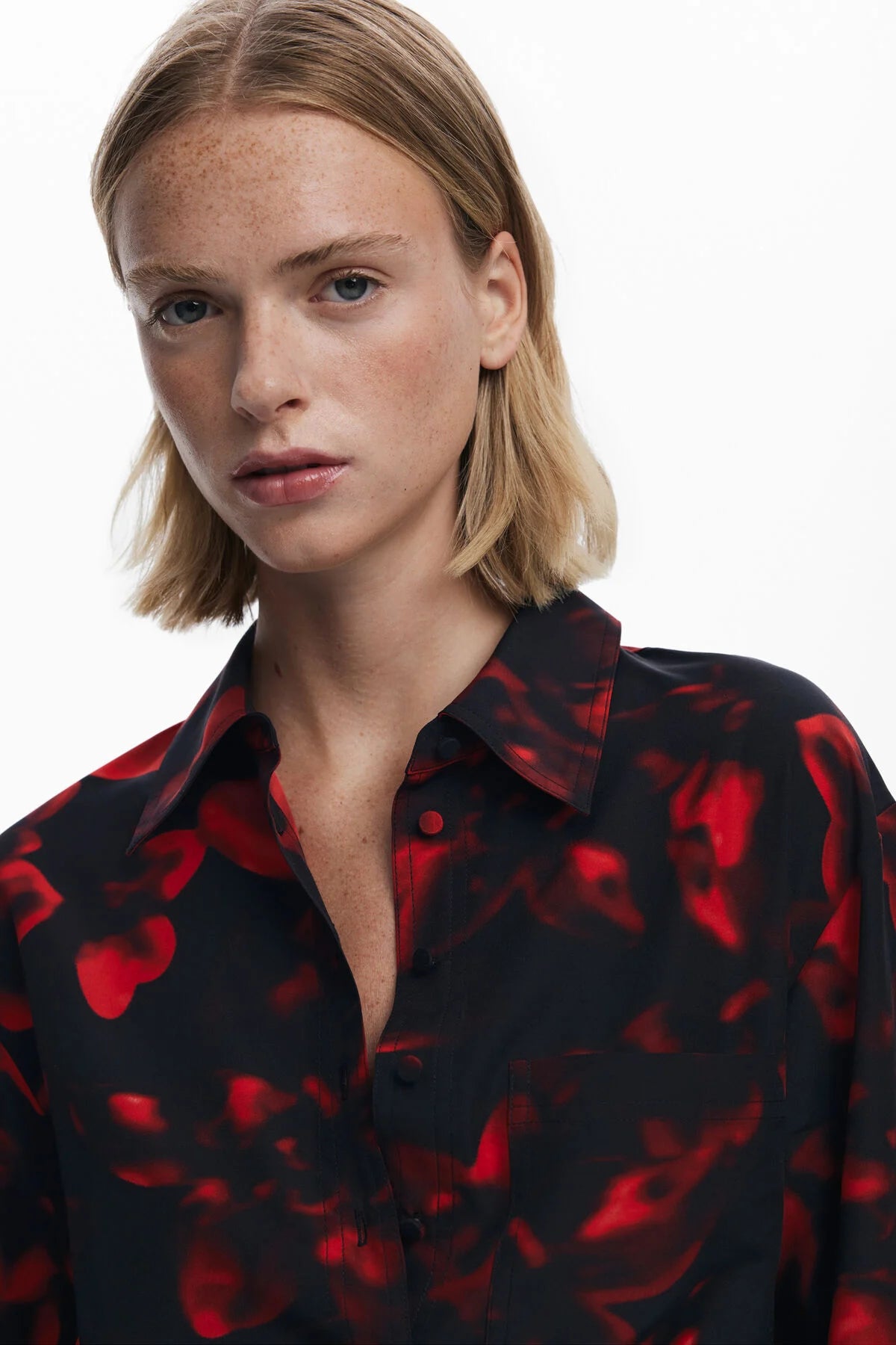Woman wearing a black shirt with red pattern against a white background
