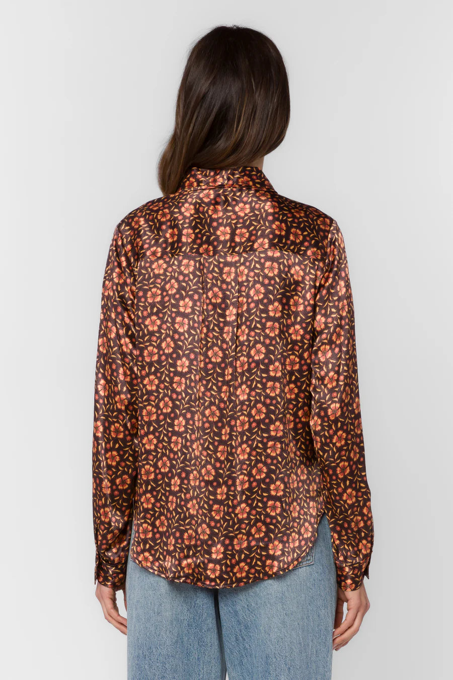 Person wearing a floral patterned shirt with a plain background