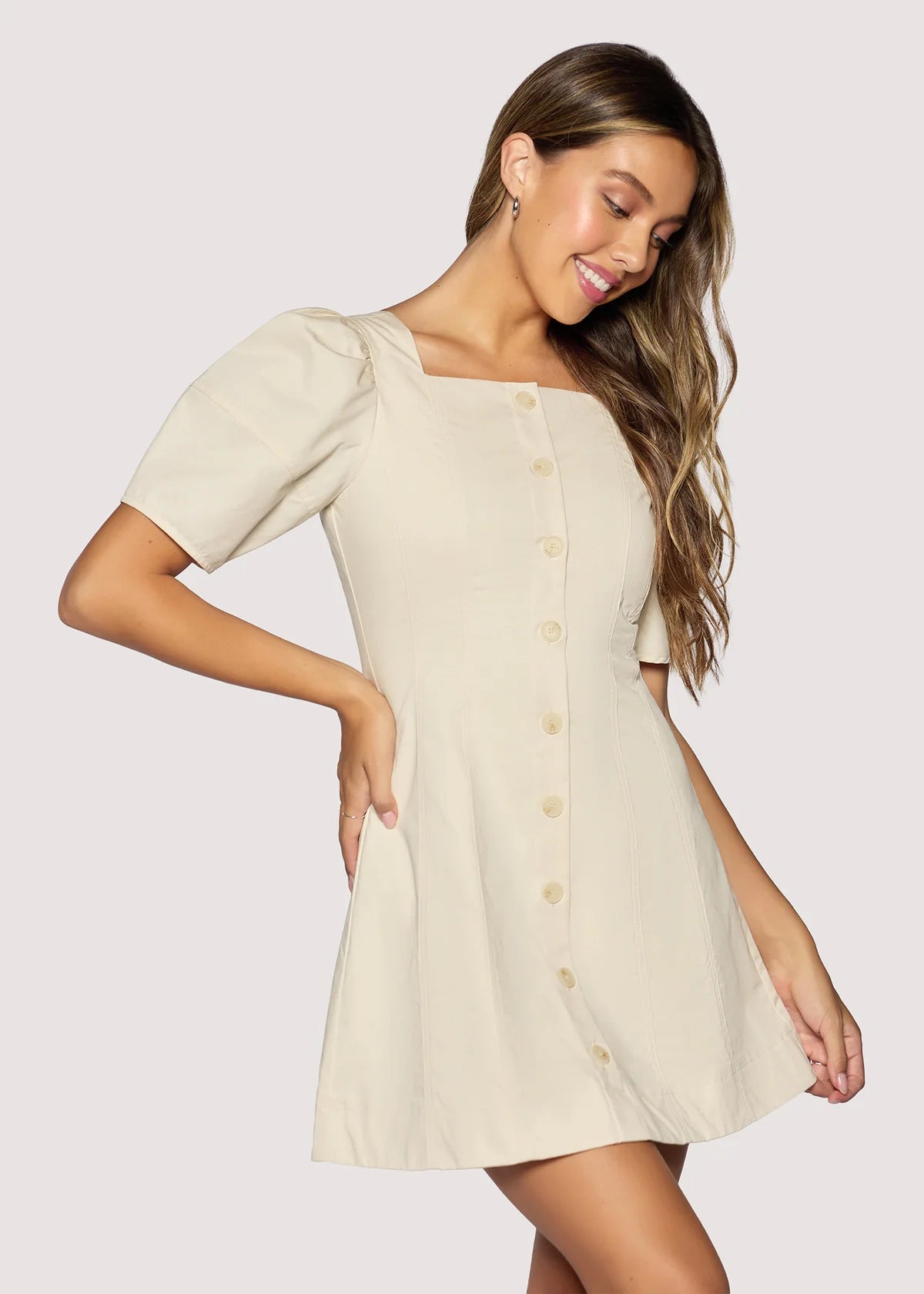 Woman wearing a beige dress with a plain background