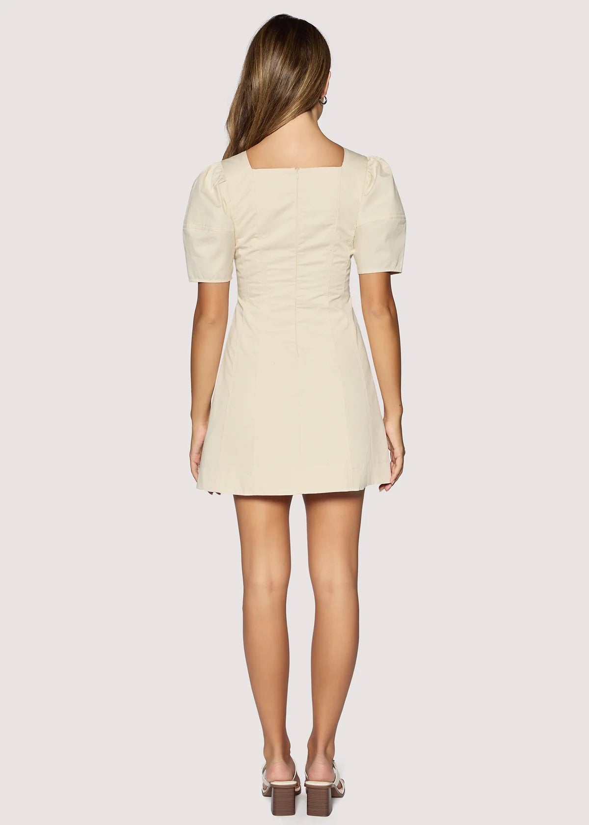 Woman wearing a beige dress on a white background