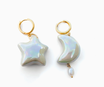 Star and moon-shaped earrings with pearl accents on a white background