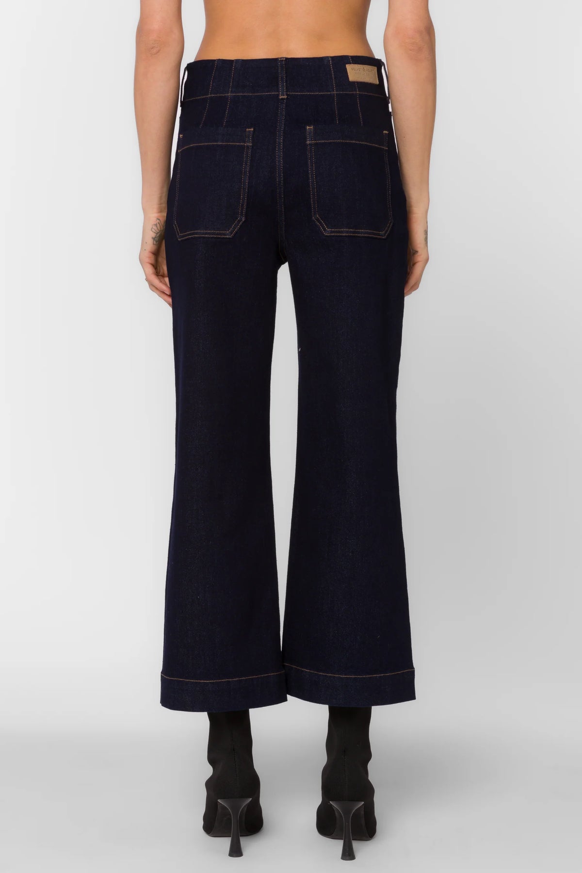 Dark blue wide-leg jeans worn by a person on a white background