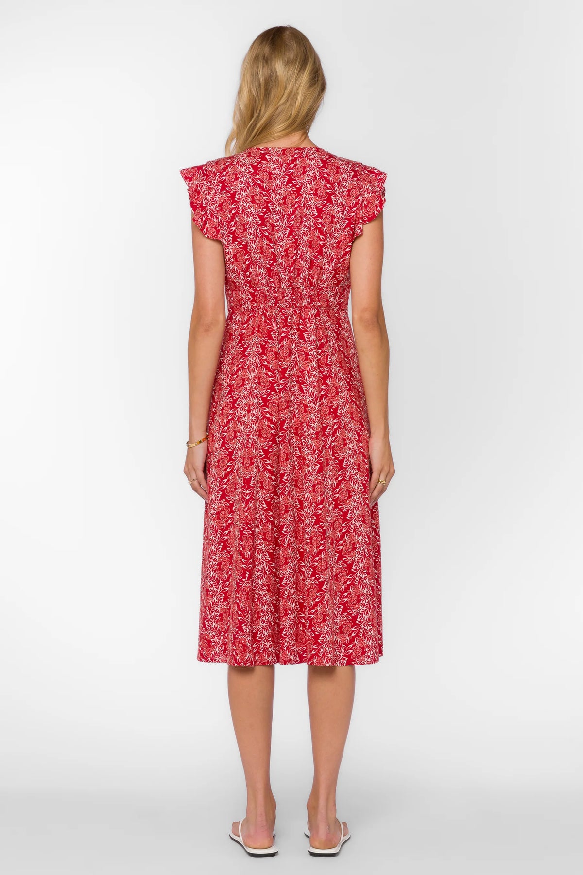 Woman wearing a red floral dress on a white background
