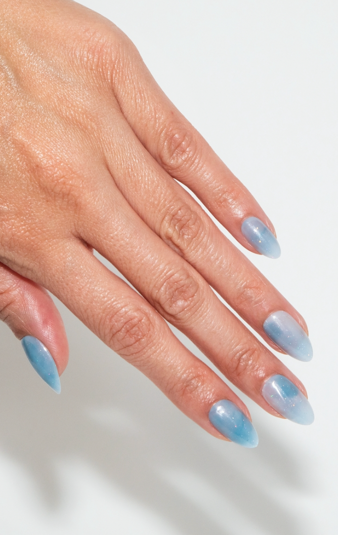 Hand with light blue nail polish on a white background