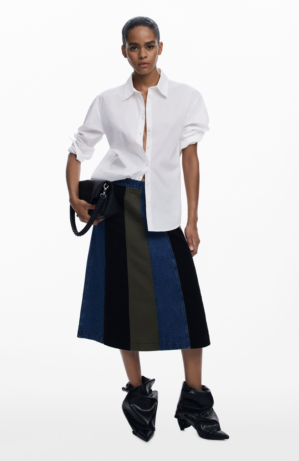 Person wearing a white shirt and black and blue skirt on a white background