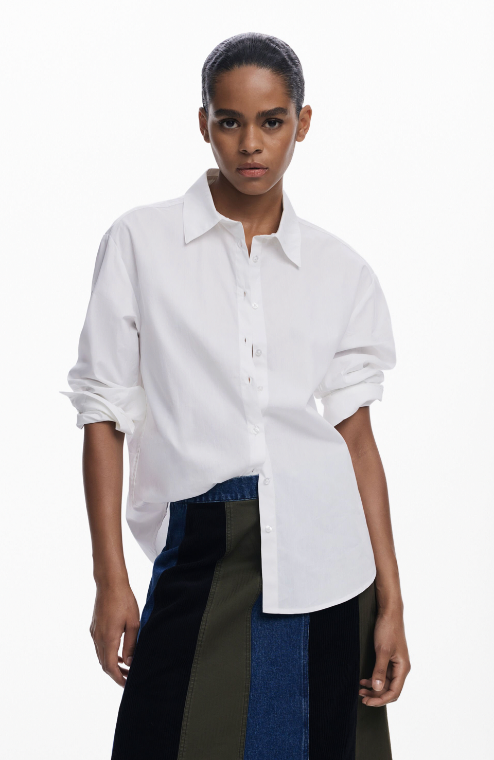 Woman wearing a white shirt and dark pants on a white background