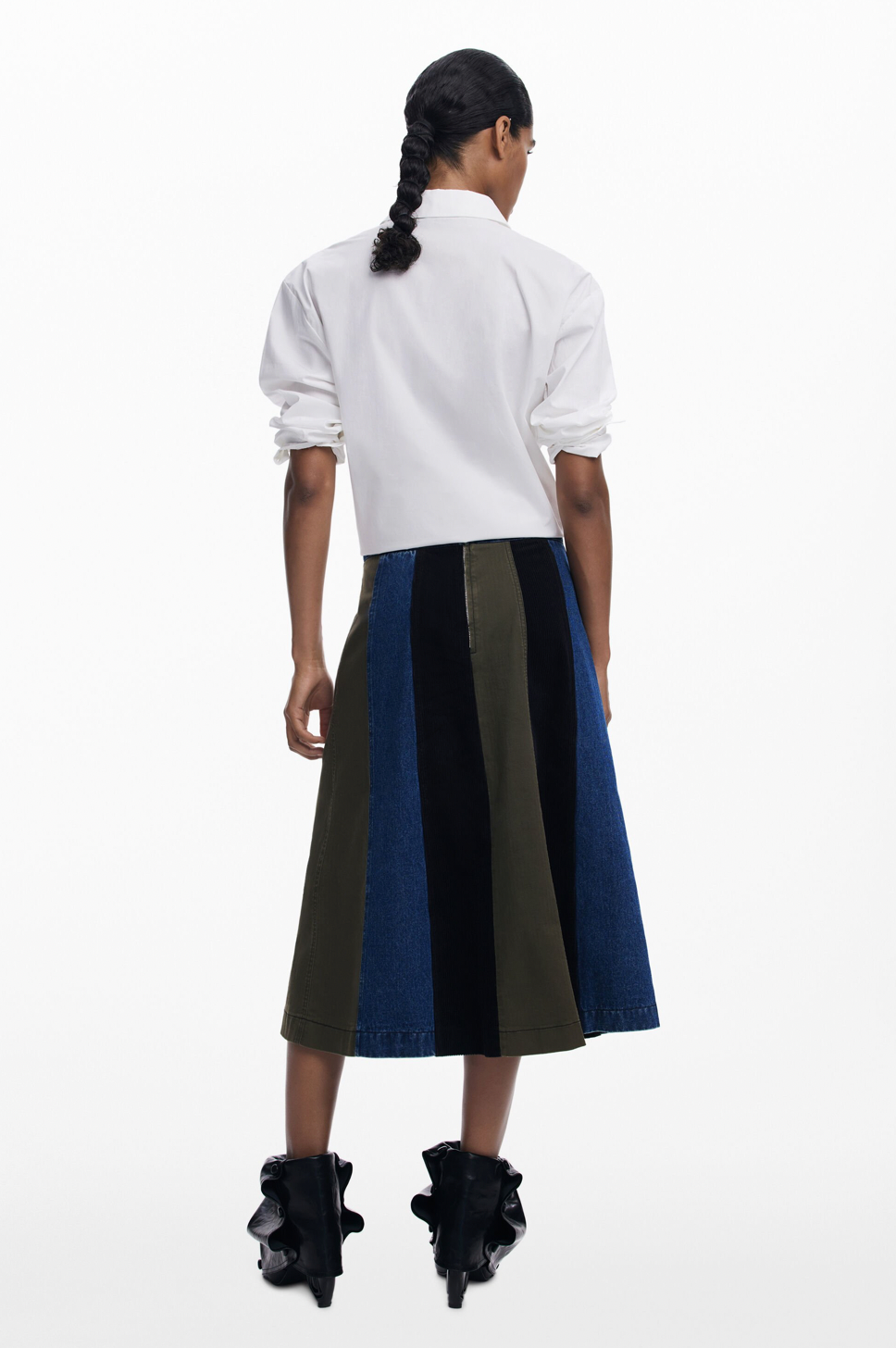 Person wearing a white shirt and a striped skirt on a white background