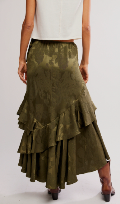 Green tiered skirt worn by a person on a white background
