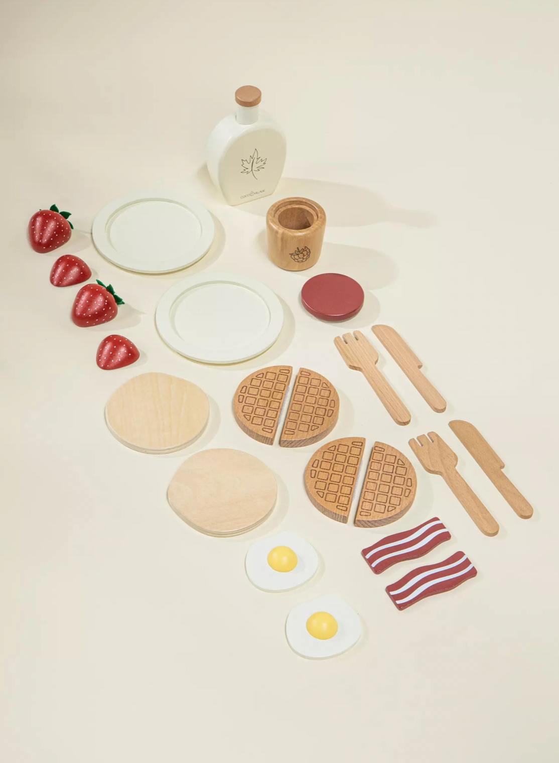Wooden toy food set including waffles, eggs, and fruits on a beige background