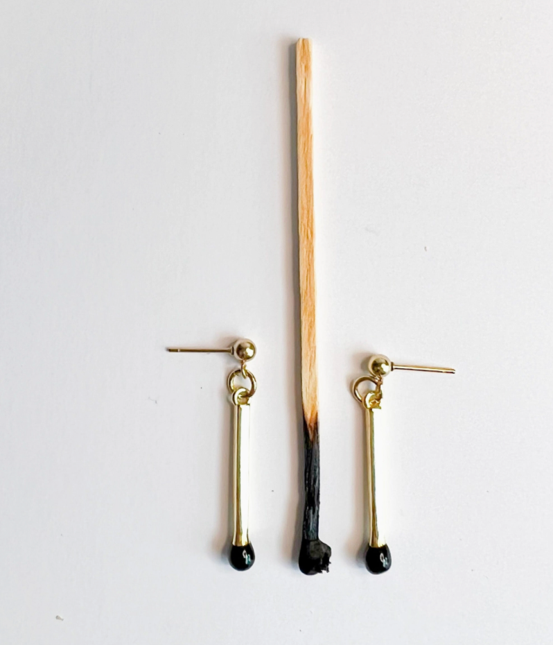 Pair of gold earrings with black accents on a white background
