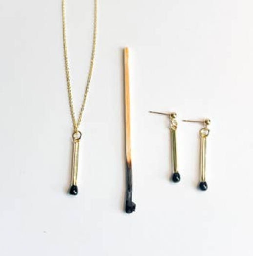 Gold necklace and earrings with black accents on a white background