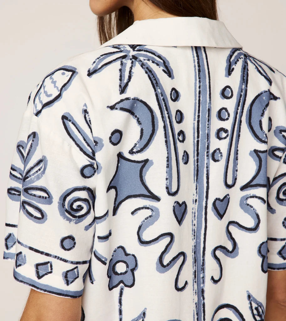 White shirt with blue floral patterns on a plain background