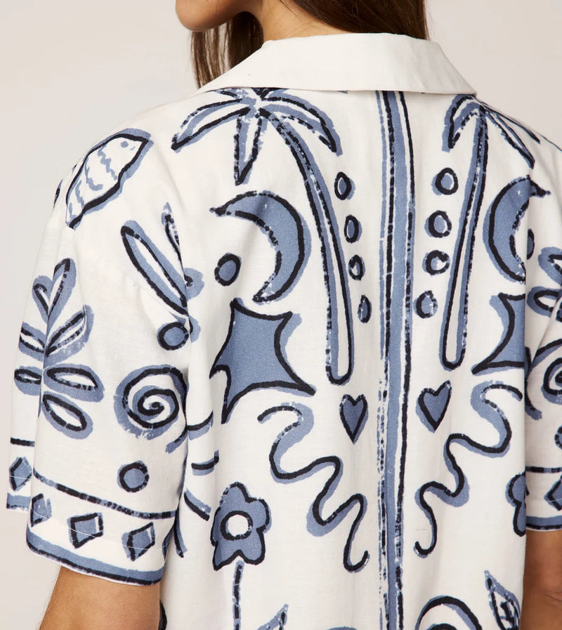 White shirt with blue floral patterns on a plain background