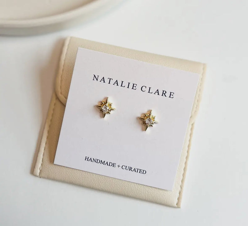 Star-shaped earrings on a 'Natalie Clare' branded card with a beige border.