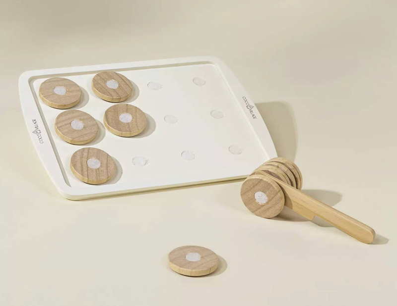 Wooden toy with circular pieces and a honey dipper on a beige background