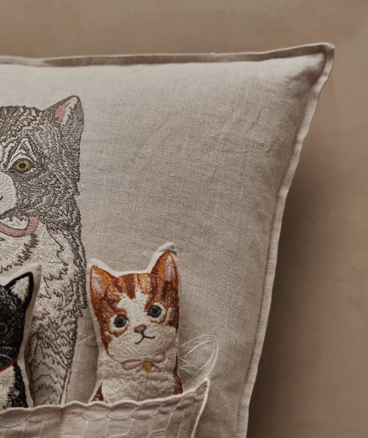 Decorative pillow with embroidered cats on a beige background