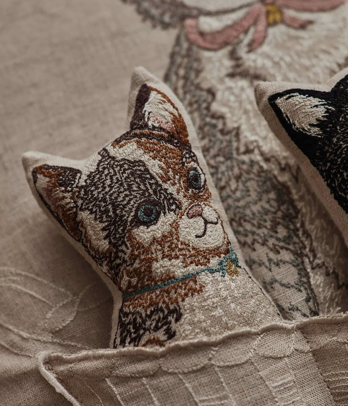 Decorative pillow with a cat design on a textured fabric background