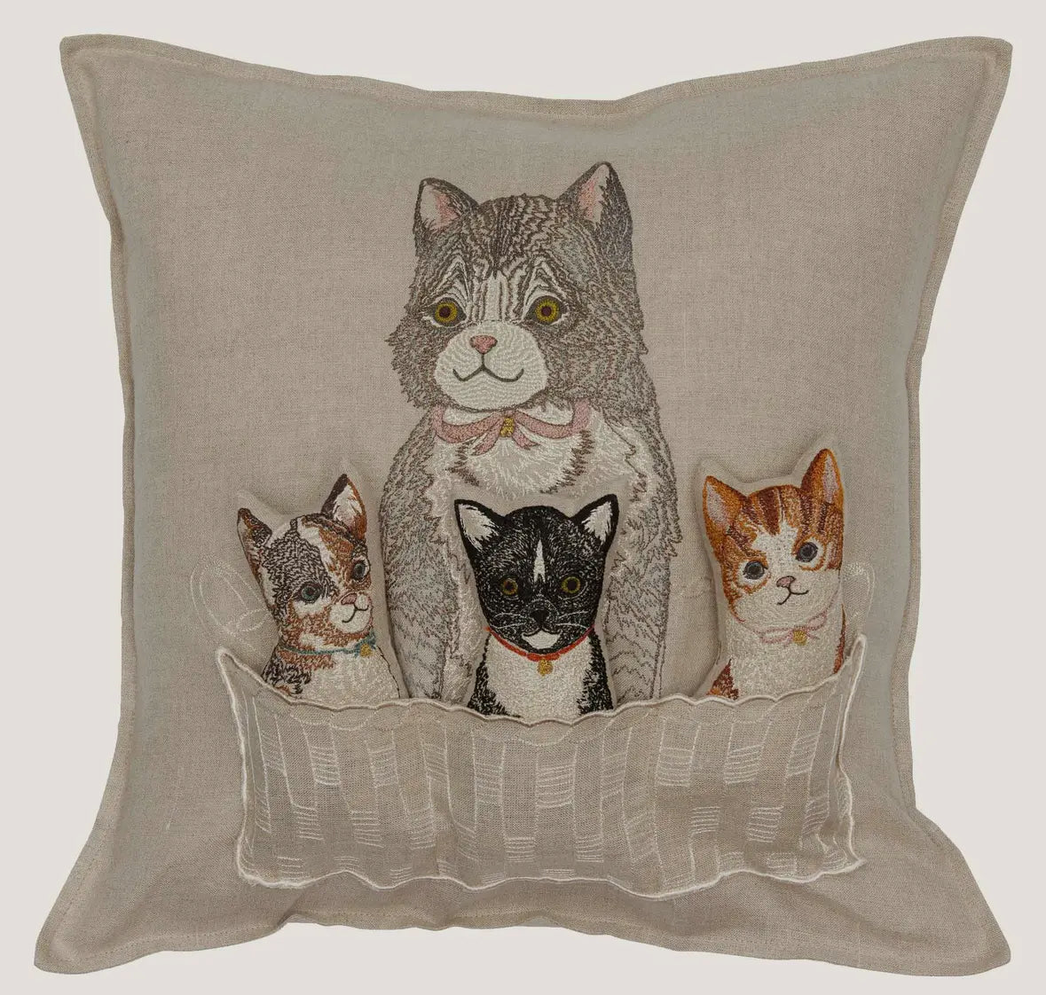 Decorative pillow with embroidered cats in a basket on a beige background