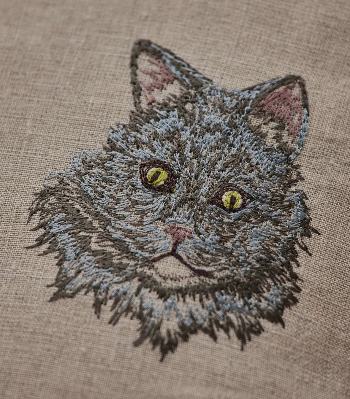 Embroidered design of a cat's face on fabric