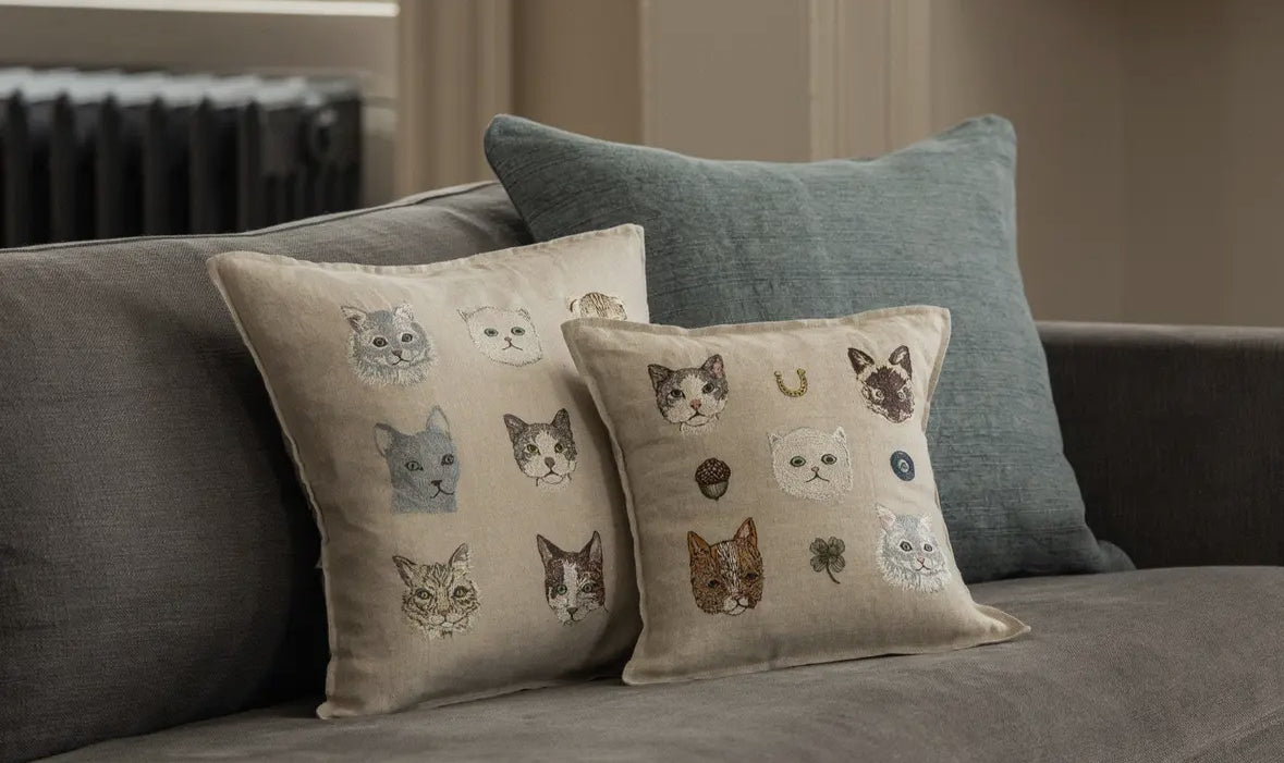 Decorative pillows with cat patterns on a sofa