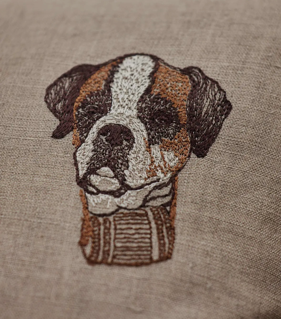 Embroidered patch of a dog's face on a textured fabric background