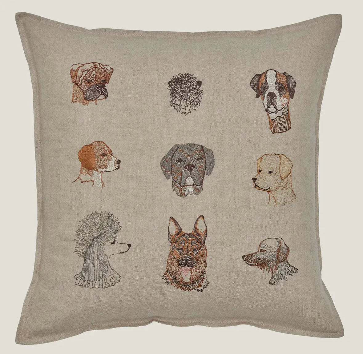 Pillow with embroidered dog faces on a beige background