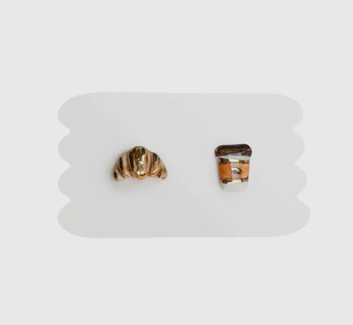 Pair of gold and brown stud earrings on a white card