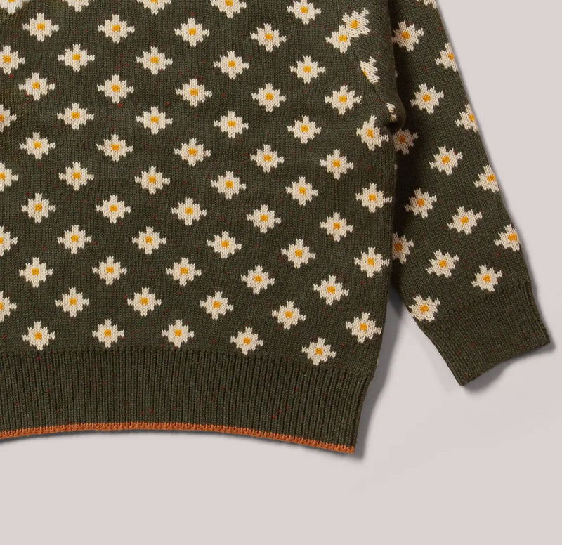 Green sweater with white daisy pattern on a light gray background