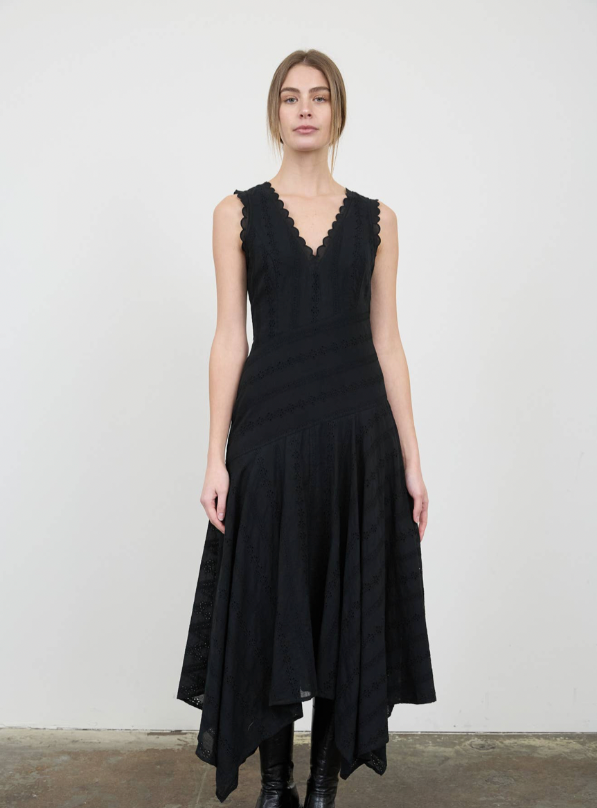 Woman wearing a black sleeveless dress against a plain background