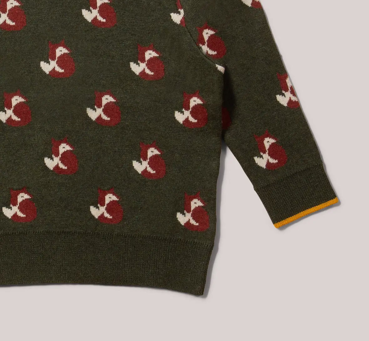 Green sweater with red and white fox pattern on a light gray background