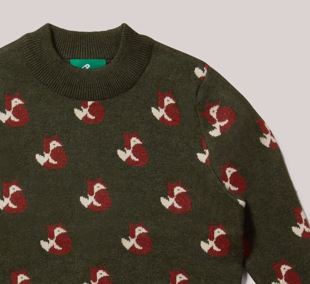 Green sweater with fox pattern on a light gray background