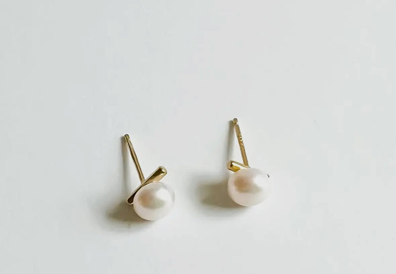 Pair of pearl earrings on a light gray background