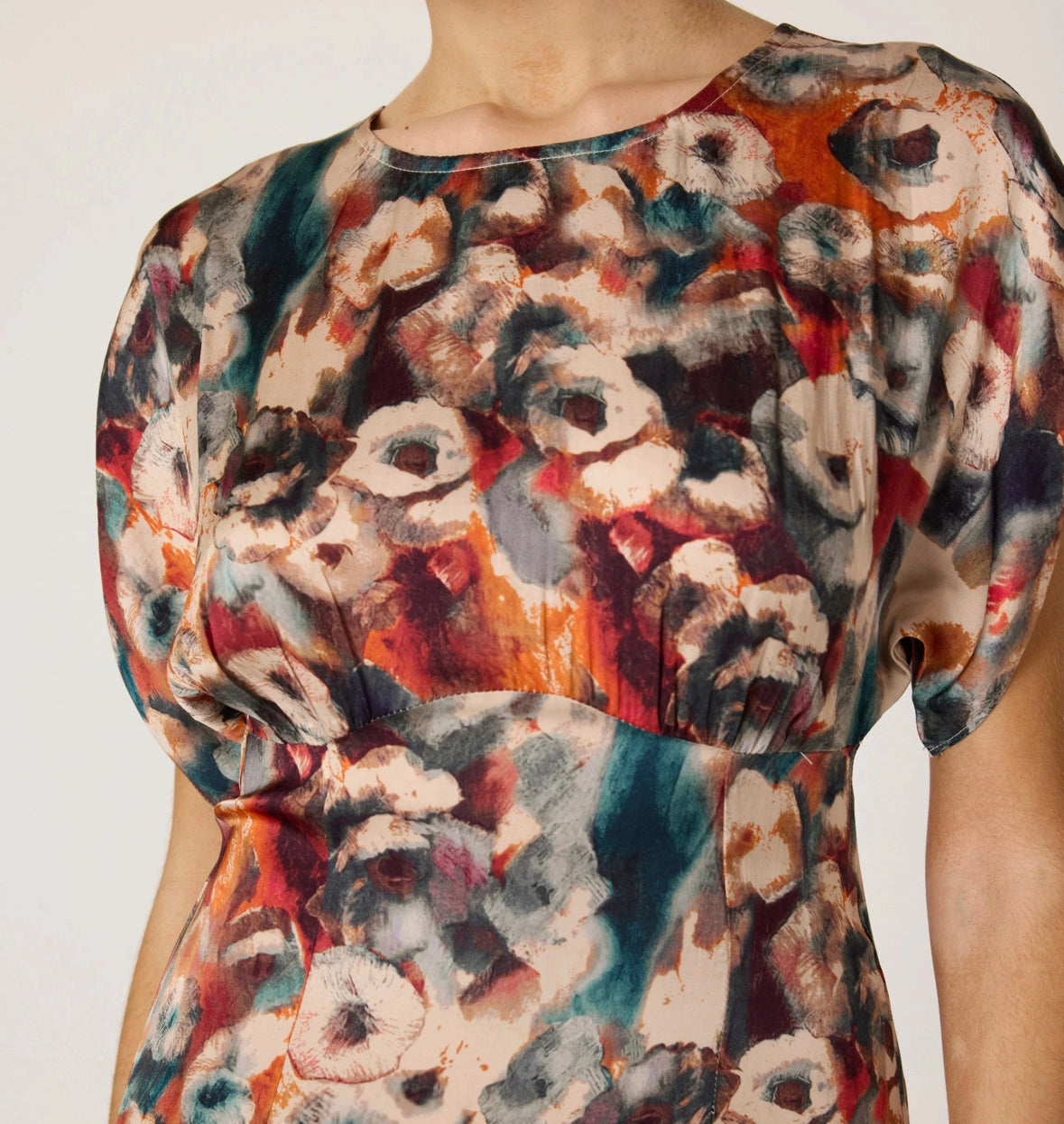 Multicolored floral patterned top on a plain background