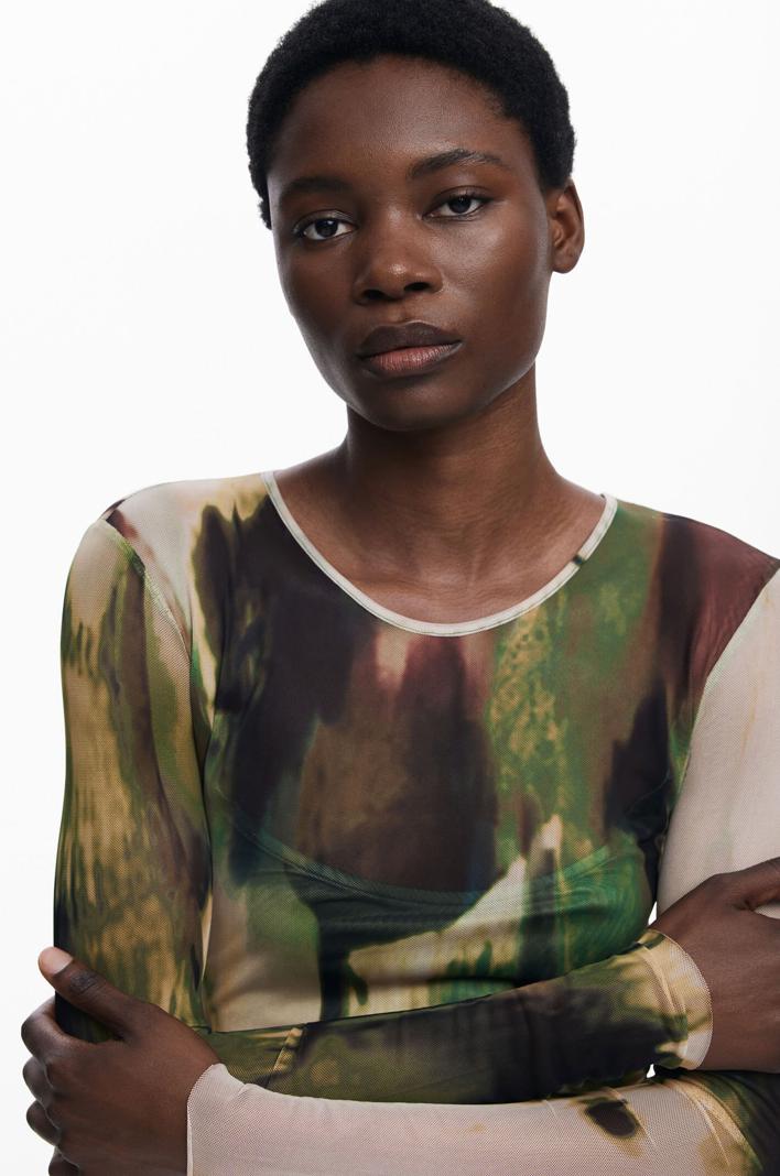 Woman wearing a patterned top with a neutral background