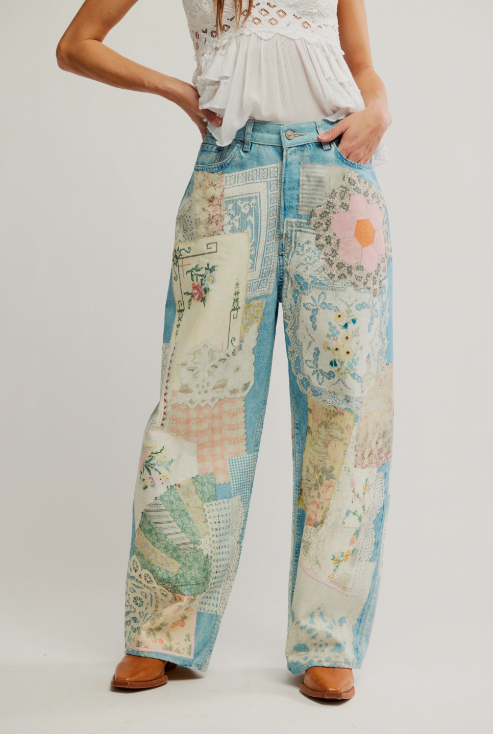 Person wearing a pair of wide-leg pants with a map and floral pattern on a plain background
