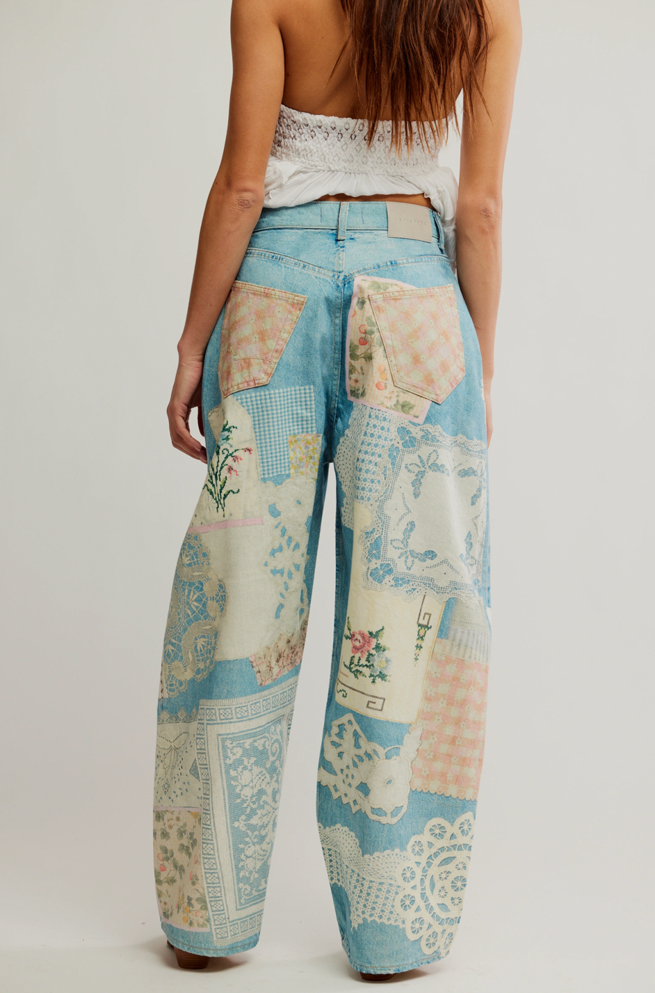 Patchwork pants with floral and geometric patterns on a plain background