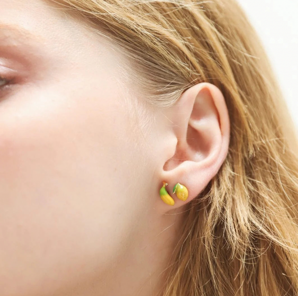 Close-up of an ear wearing a small earring with a blurred background