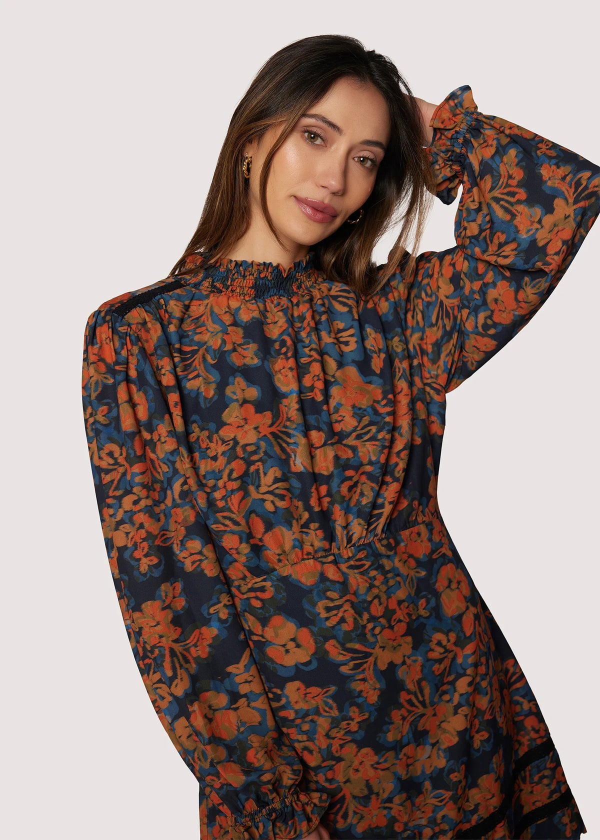 Woman wearing a floral dress with long sleeves on a white background