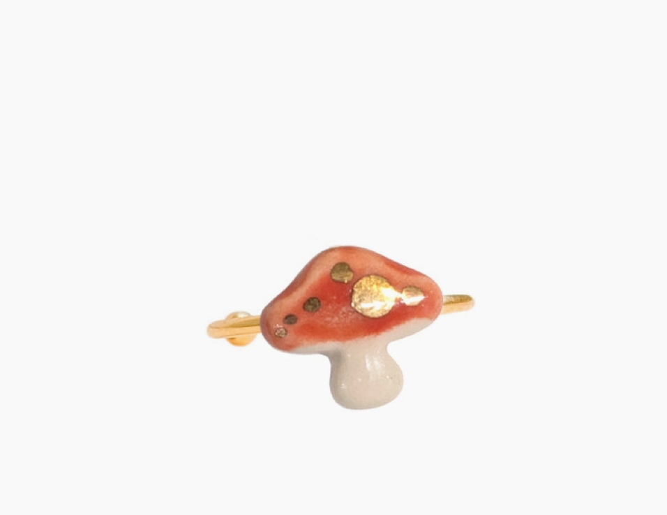 Mushroom-shaped ring with a gold accents on a white background