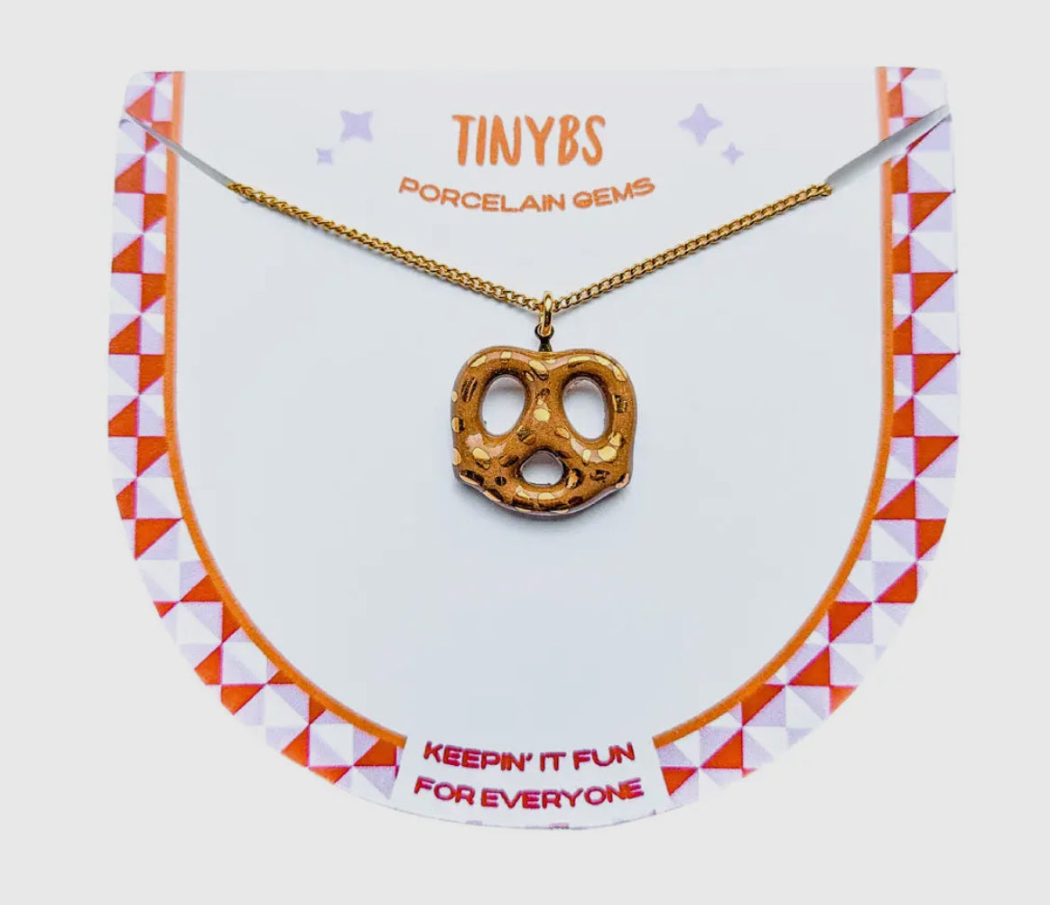 Necklace with a pretzel-shaped pendant on a branded card