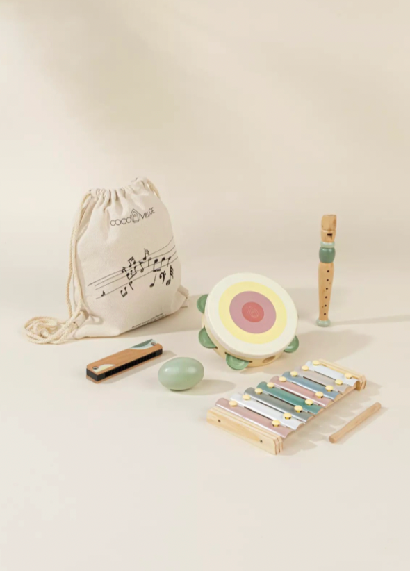 Set of children's musical instruments including a xylophone, tambourine, and drawstring bag on a light background