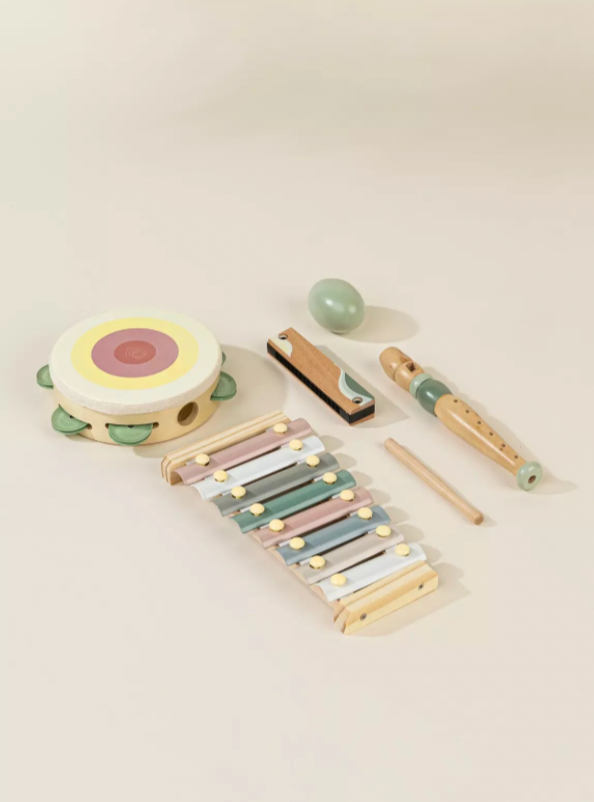 Set of children's musical instruments including a xylophone, tambourine, and other toys on a light background
