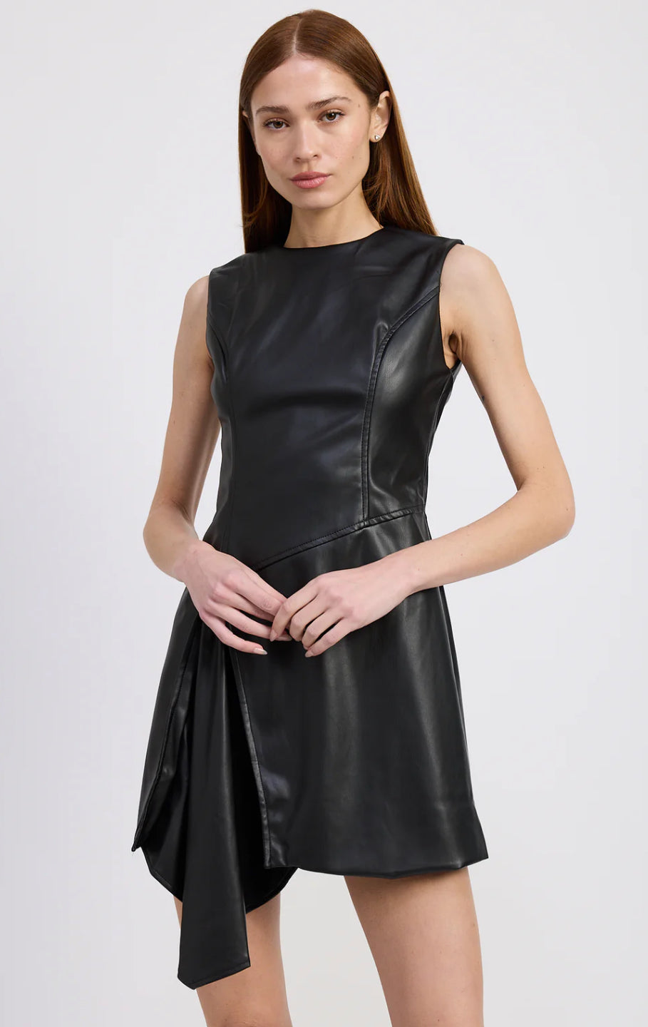 Woman wearing a black leather dress against a white background