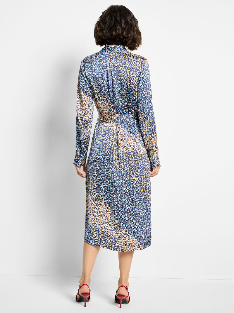 Woman wearing a patterned dress on a white background